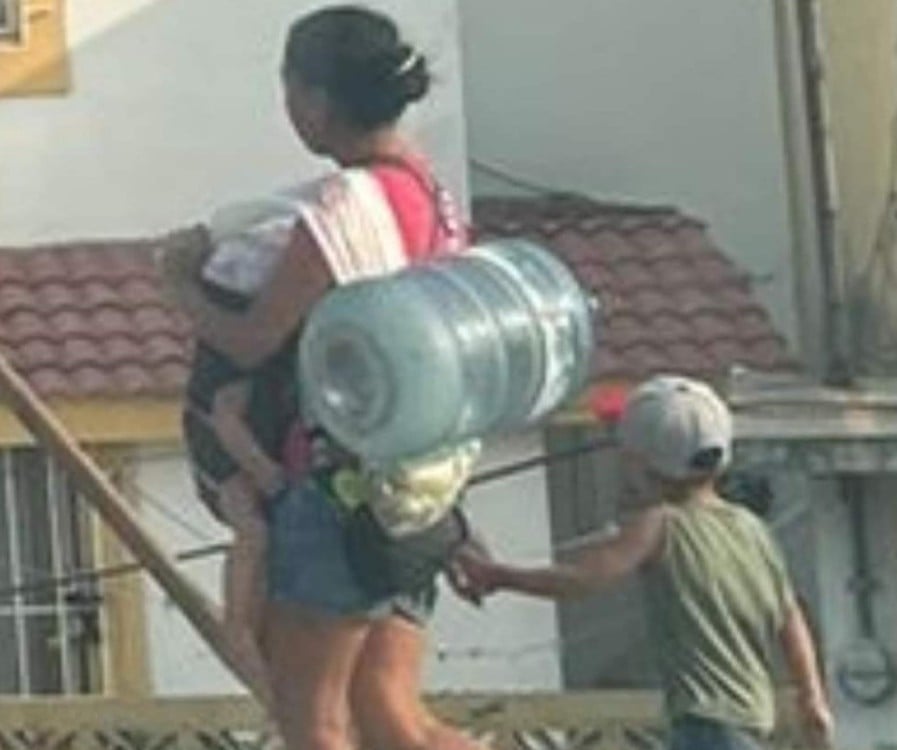 Una imagen se hace viral: Una mujer con sus hijos carga un botellón en Tampico